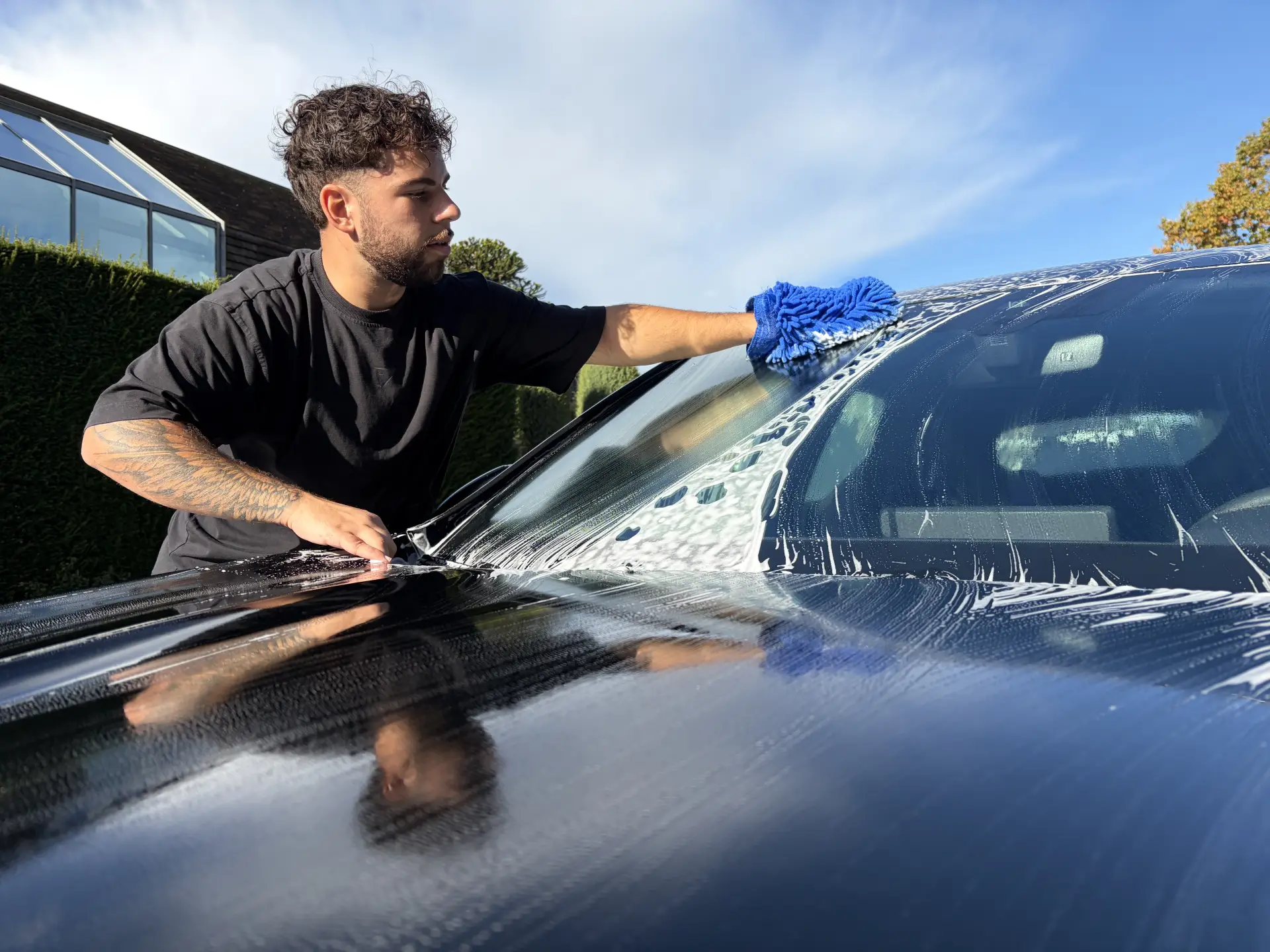 Julio wast de voorruit van een auto met de hand