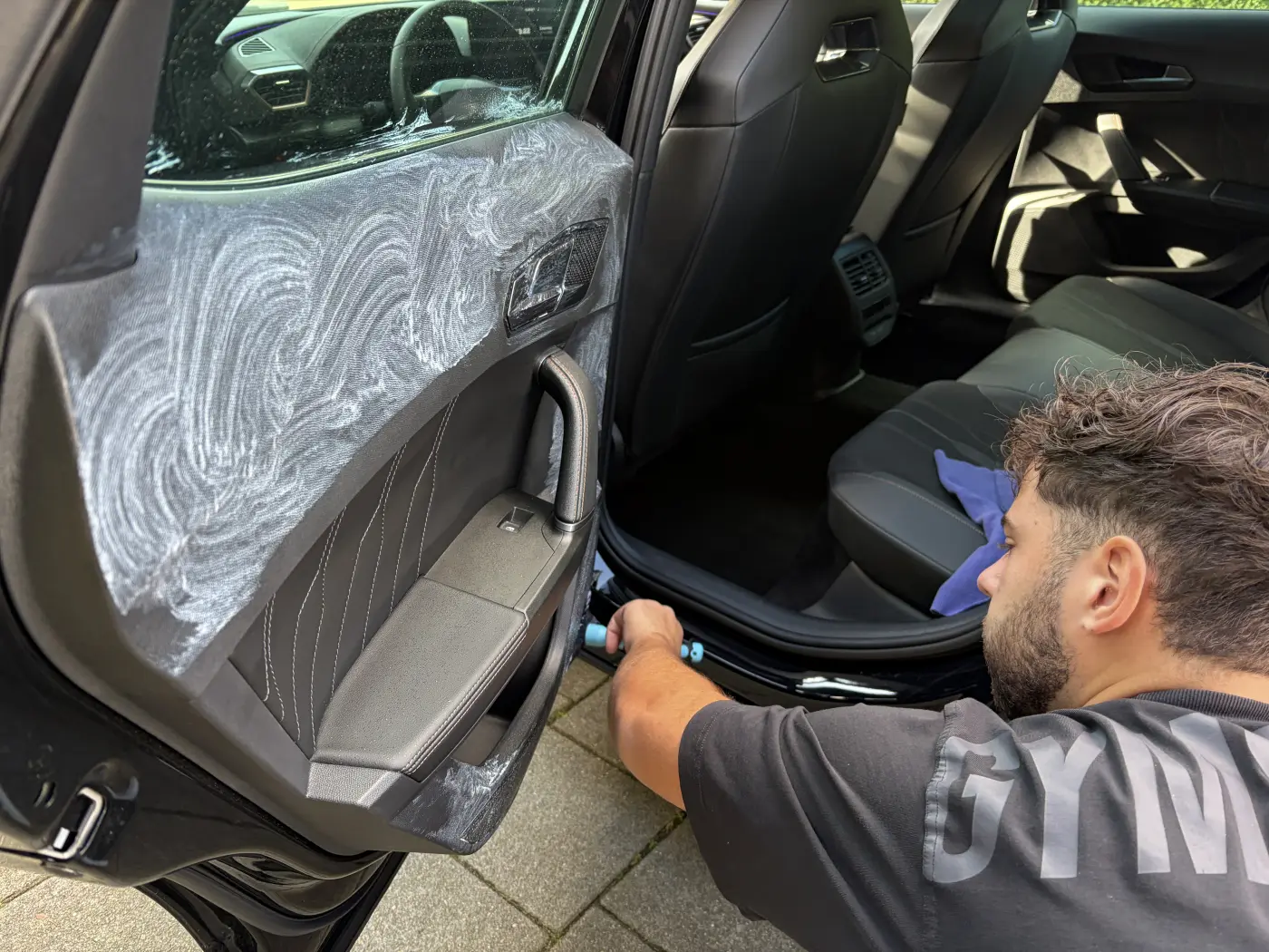 Julio maakt de deurinstap van een auto schoon